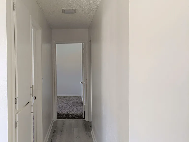 Hallway to bathroom and bedroom with storage cabinets in apartment unit at the Steckel Apartments in Santa Paula, California.