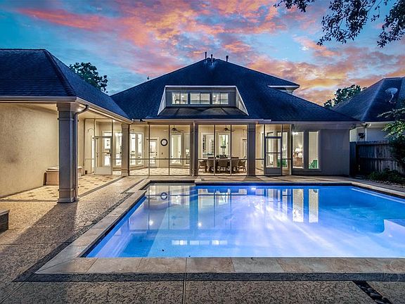 The home boasts a sparkling pool and spa as well as lush landscaping. An indoor screened patio adds to the open concept living space and offers plenty of space for entertaining in all weather.