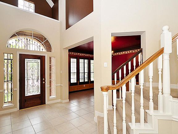Beautiful foyer with leaded glass front door accented by an arched window above and flanked by side 