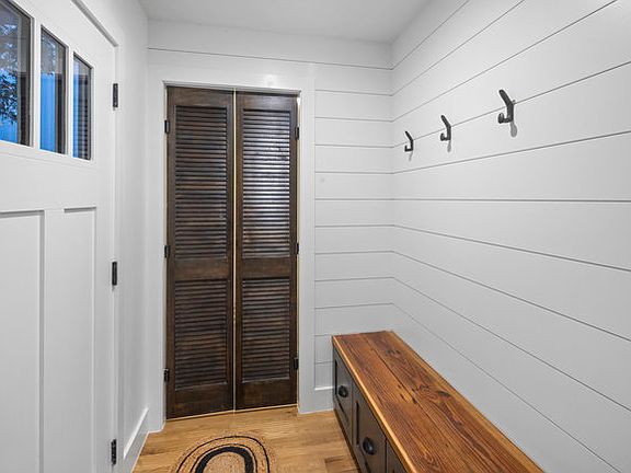 Mudroom at back entrance with double doors into laundry utility room