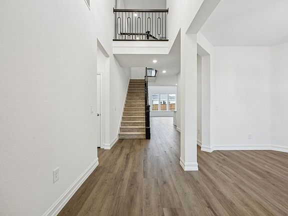 Welcoming entry into home with soaring ceilings photos depict options and features that may not be