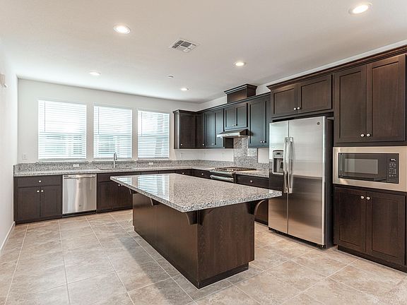 Gourmet kitchen with SS refrigerator, microwave, stove/cooktop, dishwasher, and large island