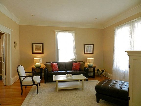 Formal living room features tall 10' ceilings, original oversized windows and craftsman fireplace
