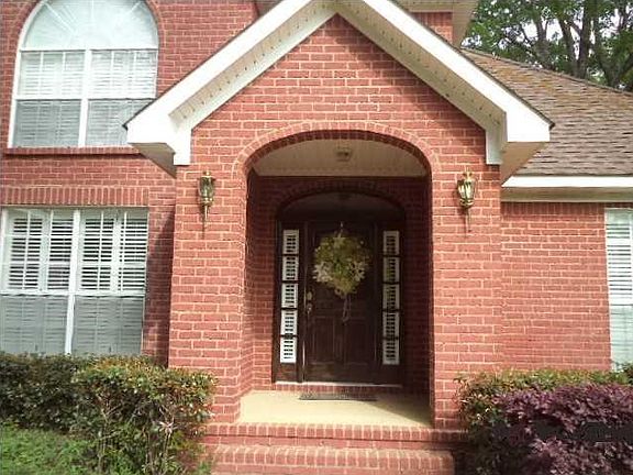 Recessed entry with 6-paneled wooden front door with side lights.