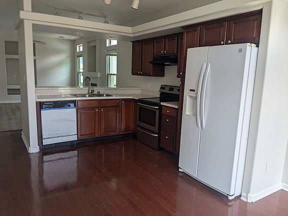 Kitchen with stove, dishwasher and refrigerator, pass through/bar area.