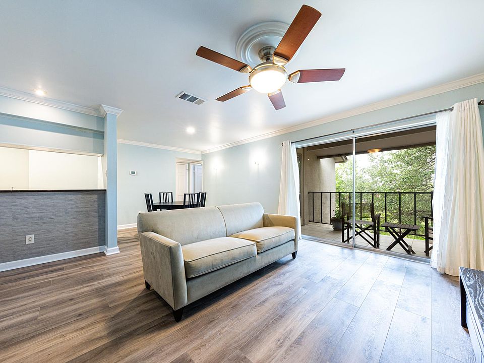 Spacious living area. If you choose to rent the unit furnished, you will have a couch, TV stand, bookshelf, dining table and chairs, queen-size bed, two end tables, patio furniture, and dishes/glasses/pots/pans. Washer/dryer included for both the furnishe