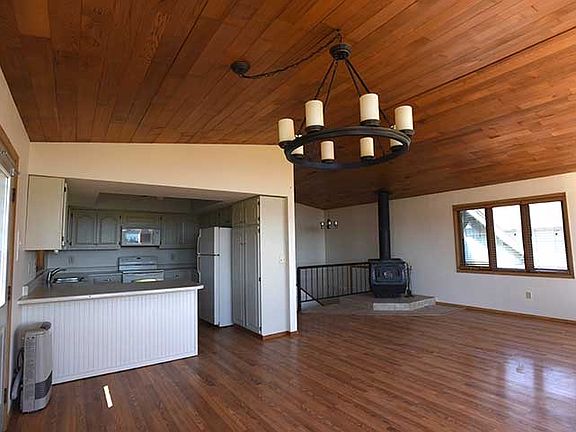 Kitchen opens onto the living room, deck access through door in left of this picture.