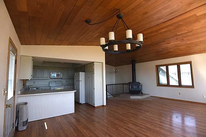 Kitchen opens onto the living room, deck access through door in left of this picture.