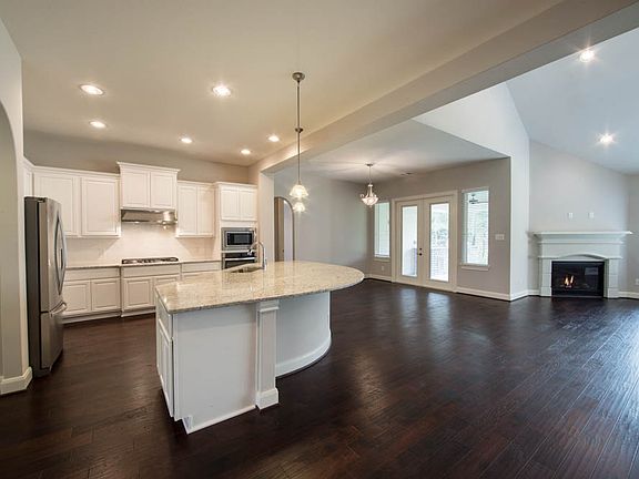 The rich, wooden floors standout next to the pristine white countertops and cabinetry.