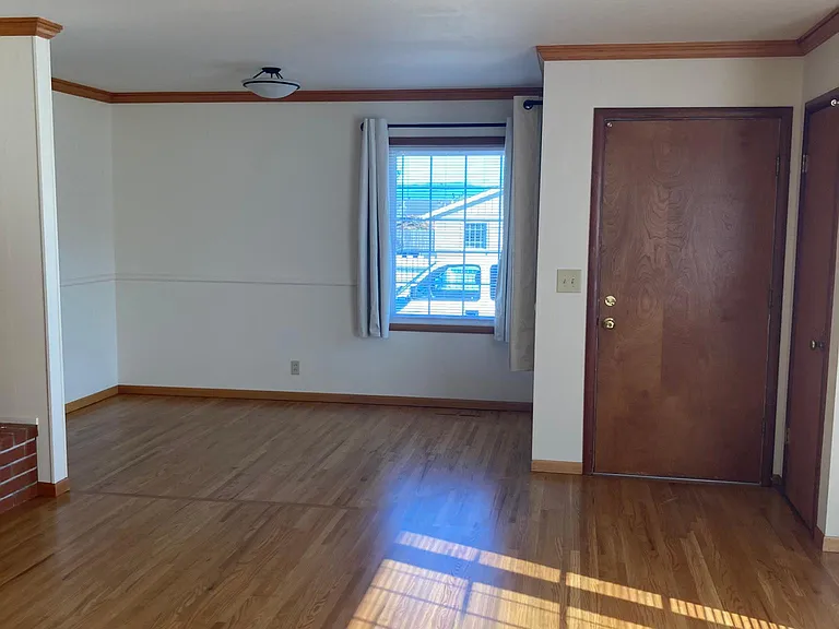 Front door, living room and dining area. New hardwood floors and window coverings.
