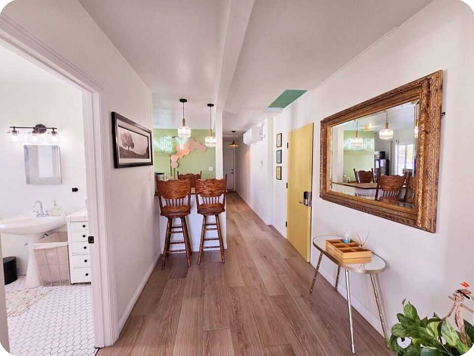 Hallway to restroom, kitchen, bedroom and back door exit.