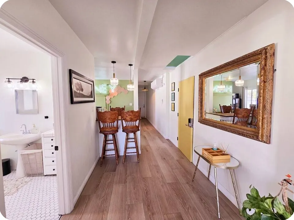Hallway to restroom, kitchen, bedroom and back door exit.