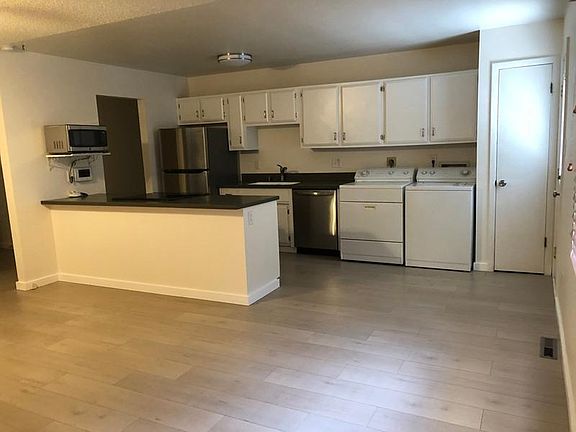 Kitchen has new refrigerator and dishwasher. Microwave and range are in island. Opens to living room.