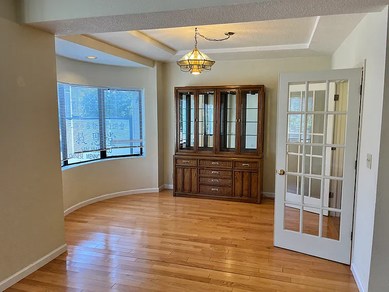 Bright dining room with cabinet to store your dishes and glasses and silverware.