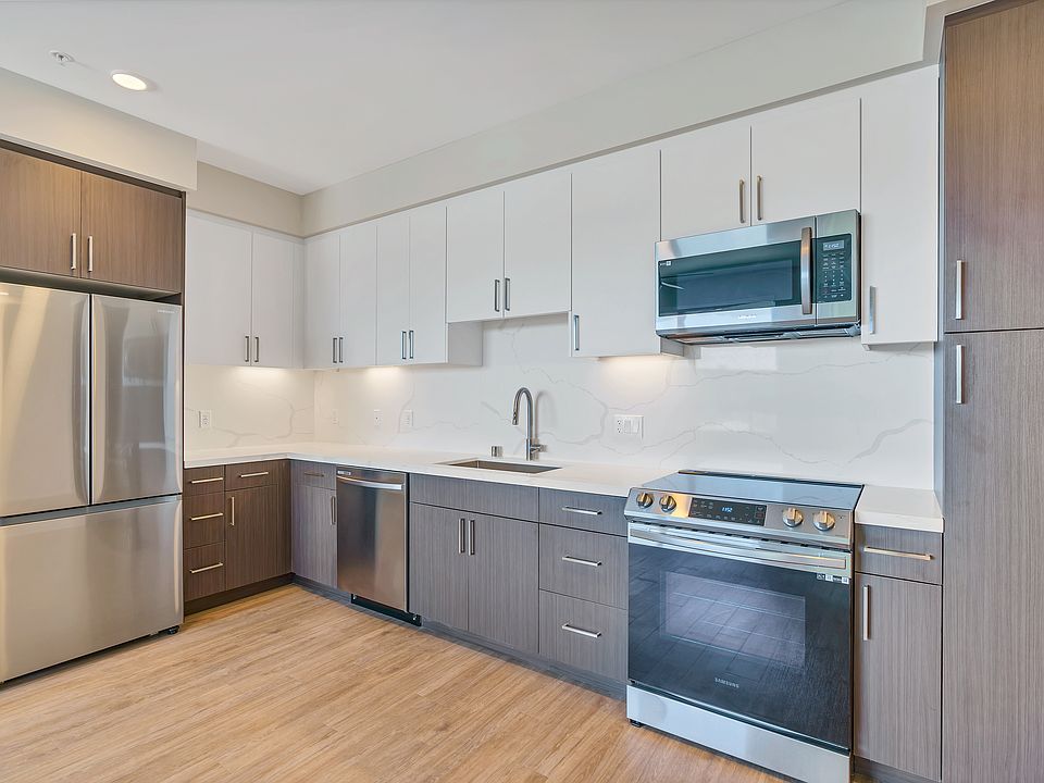 This full kitchen has a large sink, French-door fridge, dishwasher, microwave, stovetop oven, and a full pantry.