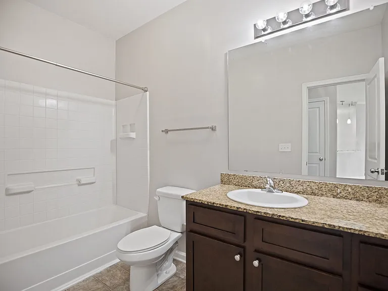 A white toilet sits next to a sink in a bathroom.