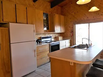 Upstairs full kitchen with double sink in island, with water filter installed, small hot water heater under island, optional pots and pans, toaster, coffee maker, Tupperware, dishes, utensils, etc.