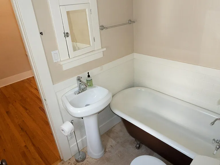 The main bathroom has a pedestal sink and clawfoot tub with shower.