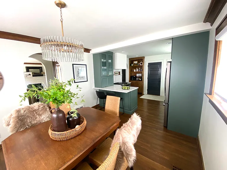 A convenient counter with barstools offers the perfect spot for snacks or food prep. A door leads to the breezeway and a single-stall garage.