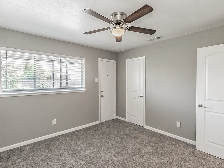 Bedrooms feature neutral finishes, ceiling fans, and ample natural light at Chapel Creek Apartments.