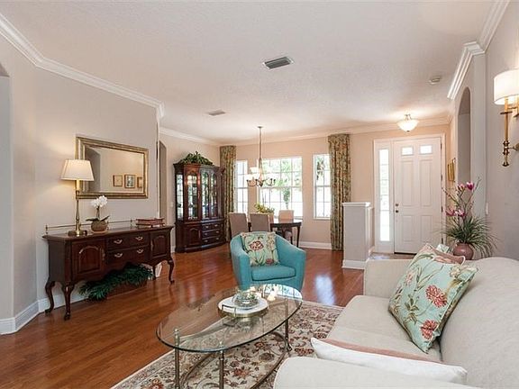 Formal living and dining area with crown molding and gleaming wood floors.