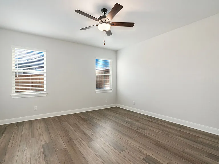The master bedroom features two windows overlooking the backyard.