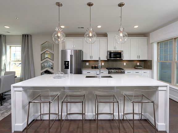 The Sydney Features White Cabinetry and an Oversized Island in the Kitchen at Crown.