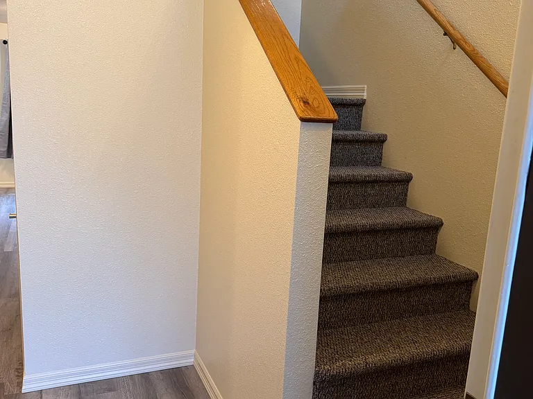 From the front door, you can go upstairs to the bedrooms, to the garage, and to the living room.