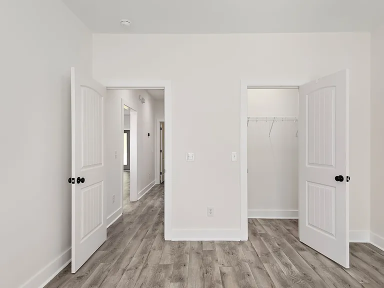 Guest bedroom/office space leading into private closet and hallway
