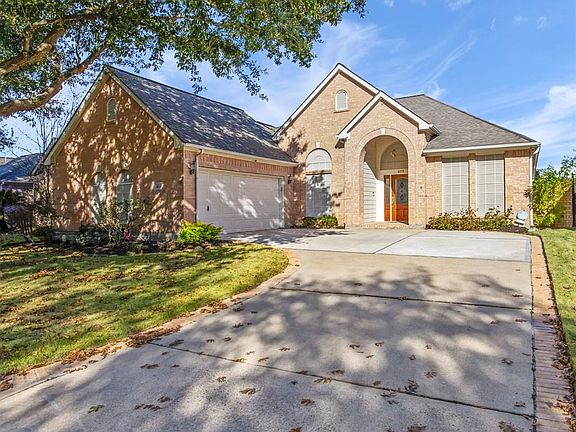 There is plenty of parking in this 2 car side-load garage.  There is a door that leads from the garage directly to the back yard.  Also notice the huge shade tree and brick pavers that line each side of the driveway.