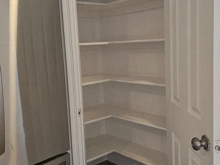 Spacious kitchen pantry with built-in shelving, offering ample storage and easy organization.