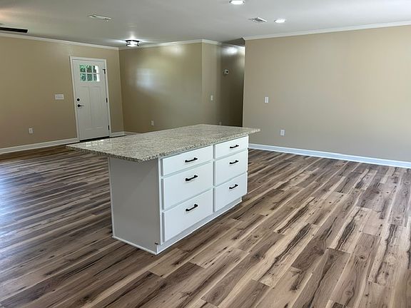 Open floor plan with 6 drawer Island with seating space for 4. View is from the laundry room doorway. Granite countertops and solid wood cabinets.
