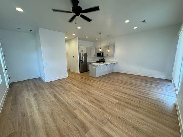 Living Room/Kitchen with 10' ceilings and ceiling fan.