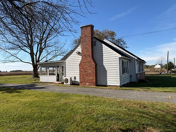 Left exterior of house with four-season room and driveway