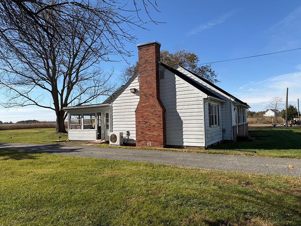 Left exterior of house with four-season room and driveway