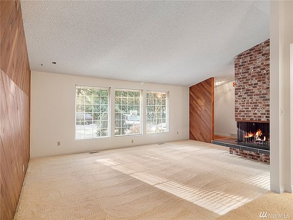 Large living room with gorgeous wood accent and fireplace.
