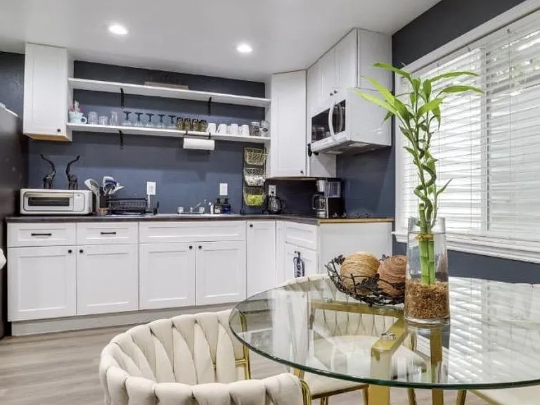 Eat-in kitchen with white cabinetry, open shelving, and small-appliance station plus a nearby dining nook.