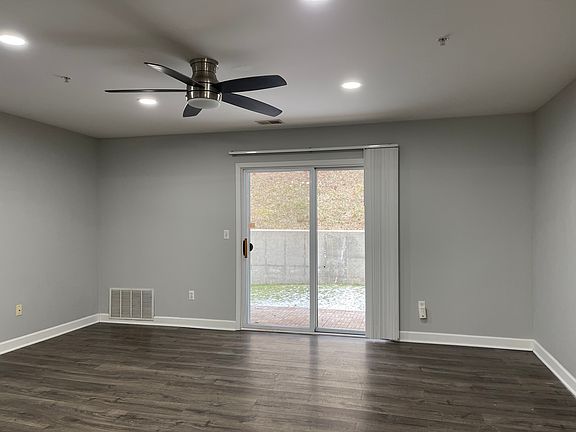 Spacious and sunny Living room opens up to the wooded and private backyard
