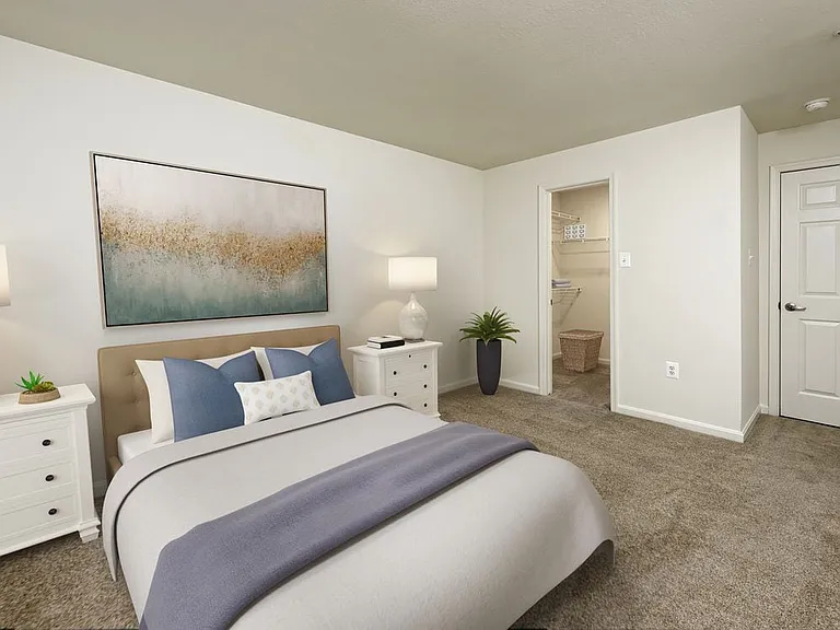 Bedroom with carpeted flooring and walk in closet