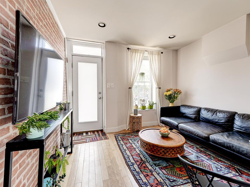 Sunny Living Room with hardwood floors and exposed brick wall!