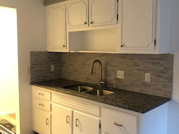 Kitchen with new granite countertop and new tiled backsplash. New sink!