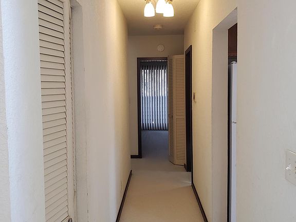 Hallway to bathroom , master bedroom, and stairs to loft. Kitchen pantry on left
