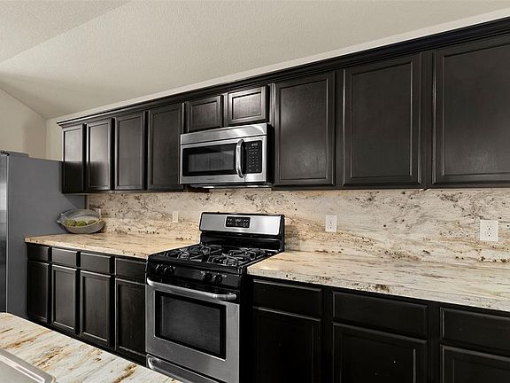 Tons of storage in the cabinets, pretty laminate countertops and backsplash.