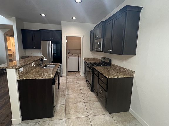 View of kitchen (laundry room at the back) from the dining area.