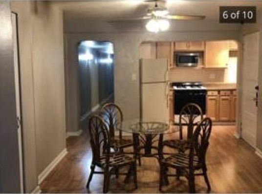 Dining area with ceiling fan. This is looking into kitchen and hallway leading to bedrooms and bathroom.