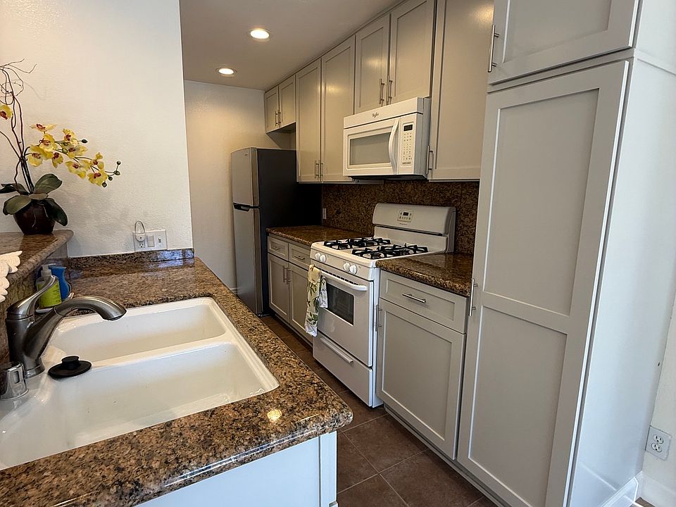 Kitchen with stove, dishwasher, microwave and refrigerator. Granite countertops.
