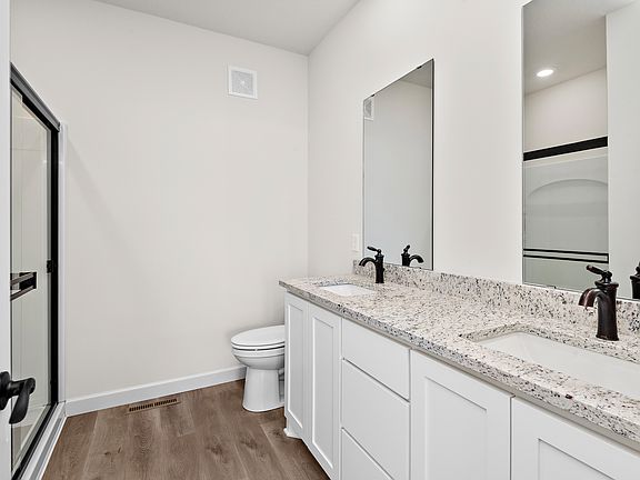 The master bedroom has a dual sink vanity and step in shower.