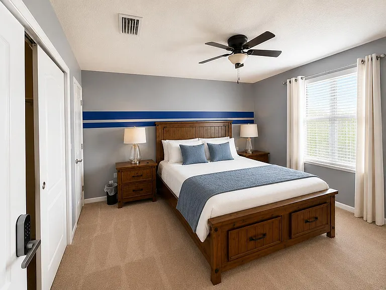 Furnished bedroom featuring a wood bed set with nightstands, a ceiling fan, and a large window with blinds and curtains.