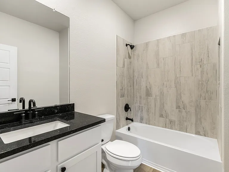 Secondary bathroom with tile detail around the shower/tub combination.