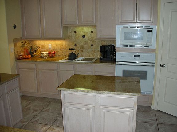 Kitchen with granite counter and travertine back splash